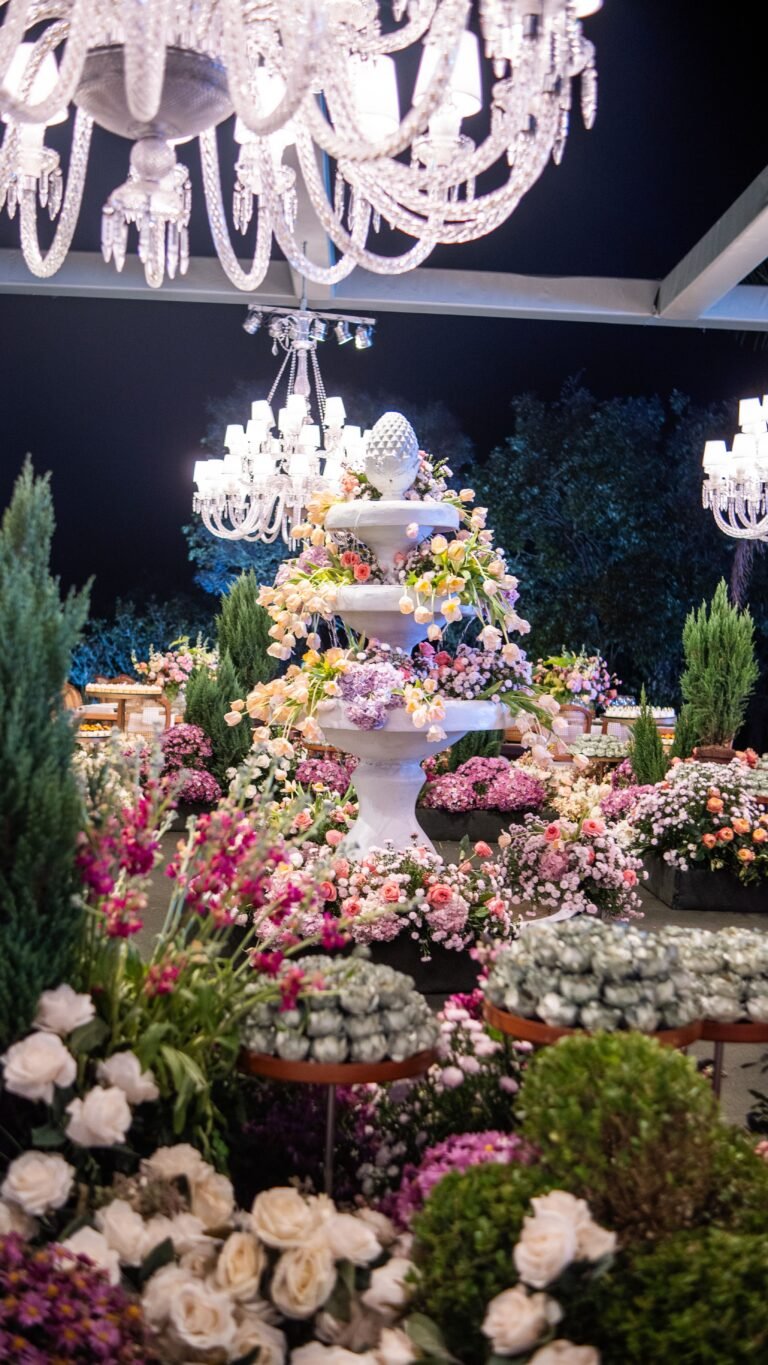 Floral arrangement illuminated by chandeliers at night